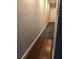 Hallway with hardwood floors and decorative rug, leading to a bright white door adding charm to the interior at 2840 Peachtree Road Nw Nw Rd # 306, Atlanta, GA 30305