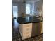 Kitchen island with black countertop, white cabinets, stainless steel dishwasher, and black-and-white tile floors at 2840 Peachtree Road Nw Nw Rd # 306, Atlanta, GA 30305