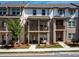 A view of the exterior of a beautiful multi-level townhome with brick and white plank accents and cozy balconies at 4065 Holland Grove Rd, Lawrenceville, GA 30044