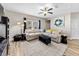 Living room featuring a large sectional sofa, ceiling fan, and a modern entertainment center at 4065 Holland Grove Rd, Lawrenceville, GA 30044