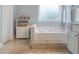Luxurious soaking tub offers a tranquil retreat in this spacious bathroom with neutral tile and decor at 475 Chippenham Ct, Alpharetta, GA 30005