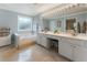 Bright bathroom with double vanity, soaking tub, neutral tiling, and a large mirror provides a spa-like experience at 475 Chippenham Ct, Alpharetta, GA 30005