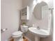 Cozy bathroom features a pedestal sink, round mirror, toilet, and built-in shelving at 475 Chippenham Ct, Alpharetta, GA 30005