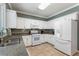 Bright kitchen with granite countertops, white cabinets, tile floors, and modern appliances at 475 Chippenham Ct, Alpharetta, GA 30005