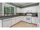 Traditional kitchen with white cabinets, granite countertops, and stainless steel appliances at 475 Chippenham Ct, Alpharetta, GA 30005