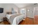 Sunlit main bedroom showcases hardwood floors, a king bed with plush bedding, and an ensuite bathroom at 475 Chippenham Ct, Alpharetta, GA 30005