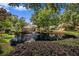 Lush community pond featuring mature trees and manicured landscaping reflecting on the water at 6300 Brookside Pl, Roswell, GA 30076