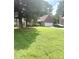 Lovely single-story home with neat landscaping, mature trees, and a brick facade two car garage at 7133 Babbling Brook Dr, Jonesboro, GA 30236