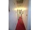 Long hallway with neutral walls and red carpeting that leads to other rooms of the house at 7133 Babbling Brook Dr, Jonesboro, GA 30236