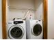 Laundry area features a new washing machine and dryer, with a shelf above, ready for convenient in-home laundry at 1587 Cronic Town Rd, Auburn, GA 30011