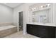 Well-lit bathroom featuring a large vanity and separate tub area with travertine tile and a modern design at 1954 Summit Trace Circle Northwest, Atlanta, GA 30318