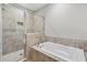 A travertine tiled bathroom offers a large vanity and a separate shower and tub with modern fixtures at 1954 Summit Trace Circle Northwest, Atlanta, GA 30318