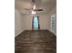 A clean and bright bedroom with wood floors, a ceiling fan, white walls, window with curtain, and a closet at 101 Royal Way, Mcdonough, GA 30252