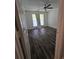 A clean and bright bedroom with wood floors, ceiling fan, window with a curtain, and a white painted door at 101 Royal Way, Mcdonough, GA 30252