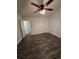 A clean and bright bedroom with wood floors, a ceiling fan, white walls, and a white painted door at 101 Royal Way, Mcdonough, GA 30252