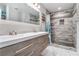 Updated bathroom featuring double sinks, decorative lighting, a large mirror, and a tiled shower at 232 Whitworth Sw Dr, Atlanta, GA 30331