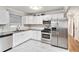 Modern kitchen with stainless steel appliances, granite countertops, white cabinets, tile flooring, and adjacent hallway at 232 Whitworth Sw Dr, Atlanta, GA 30331