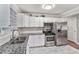 Modern kitchen with stainless steel appliances, granite countertops, white cabinets, tile flooring, and ample counter space at 232 Whitworth Sw Dr, Atlanta, GA 30331