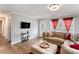 Inviting living room featuring a large sectional, hardwood floors, modern lighting, and two windows for natural light at 232 Whitworth Sw Dr, Atlanta, GA 30331