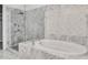 Elegant bathroom featuring a glass shower, soaking tub, and marble tile at 326 Brownstones Ne Cir, Atlanta, GA 30312