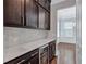 This butlers pantry features dark cabinetry, stainless hardware, marble countertops, and a beverage fridge at 326 Brownstones Ne Cir, Atlanta, GA 30312
