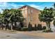 Brick corner lot townhouse building surrounded by mature, lush trees, shrubs, and manicured lawns at 326 Brownstones Ne Cir, Atlanta, GA 30312