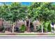Brick townhouse with meticulously maintained landscaping, sidewalk, and mature trees at 326 Brownstones Ne Cir, Atlanta, GA 30312