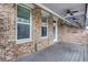 Wide covered patio with brick siding, ceiling fans, and a grey wooden floor at 326 Brownstones Ne Cir, Atlanta, GA 30312