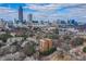 Stunning aerial view of brick condo building nestled amongst trees with the city skyline in the background at 395 Central Park Ne Pl # 610, Atlanta, GA 30312