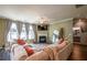 Bright open concept living room featuring hardwood floors, fireplace, and plush white sofa set at 13568 Scenic Pkwy, Covington, GA 30014