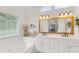 Bright bathroom featuring double sinks, granite countertop, large mirror, and a garden tub at 3190 Red Rose Dr, Powder Springs, GA 30127