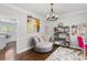 Cozy office space with a round chair, built-in shelves, and natural light from the large window at 3190 Red Rose Dr, Powder Springs, GA 30127
