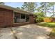 A brick home's exterior showcases a concrete back patio and sliding glass doors to the outdoor living area at 4149 Indian Lake Cir, Stone Mountain, GA 30083