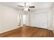 Bedroom with ceiling fan, hardwood floors, and access to hall and ensuite bath at 4149 Indian Lake Cir, Stone Mountain, GA 30083