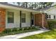 Close up of home's facade showing brick and white wood accents, front door, windows, and landscaping at 4149 Indian Lake Cir, Stone Mountain, GA 30083