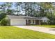Charming single-story home with a well-manicured lawn, attached two car garage, and mature trees at 4149 Indian Lake Cir, Stone Mountain, GA 30083