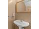 Stylish half bathroom with a pedestal sink, gold trimmed mirror, and neutral paint at 5900 Union Woods Way, Union City, GA 30291