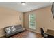 Cozy bedroom with a grey couch, wood floors, and natural light from the window at 5900 Union Woods Way, Union City, GA 30291