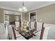 Bright dining room with glass table, seating for eight, chandelier, and wainscoting at 5900 Union Woods Way, Union City, GA 30291