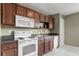 This spacious kitchen has granite countertops, white appliances, and dark wood cabinets at 5900 Union Woods Way, Union City, GA 30291