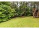 Well-maintained backyard with a grassy lawn and stairs leading to an elevated area at 616 Piping Rock Pt, Lawrenceville, GA 30043