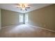 Spacious carpeted bedroom with two windows and a ceiling fan at 616 Piping Rock Pt, Lawrenceville, GA 30043