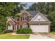 Charming two-story brick home featuring a well-maintained lawn and attached two car garage at 616 Piping Rock Pt, Lawrenceville, GA 30043