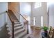 Welcoming foyer with hardwood floors, staircase, and natural light pouring through a window above the door at 616 Piping Rock Pt, Lawrenceville, GA 30043
