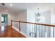 Spacious hallway with wood floors, white railing, and a decorative chandelier at 616 Piping Rock Pt, Lawrenceville, GA 30043