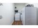 A laundry room featuring a washing machine, dryer, refrigerator, and wooden flooring at 616 Piping Rock Pt, Lawrenceville, GA 30043
