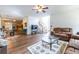 Open-concept living room features hardwood floors, comfortable seating, a staircase, and seamless flow into the dining and kitchen areas at 616 Piping Rock Pt, Lawrenceville, GA 30043