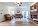 Bright living room features hardwood floors, a brick fireplace, comfortable seating, and a ceiling fan at 616 Piping Rock Pt, Lawrenceville, GA 30043