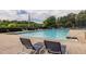 Relaxing community pool with lounge chairs surrounded by lush greenery and trees at 616 Piping Rock Pt, Lawrenceville, GA 30043