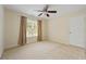 Bright bedroom with neutral carpet, a ceiling fan, and natural light from window with beige curtains at 773 Van Briggle Path, Sugar Hill, GA 30518